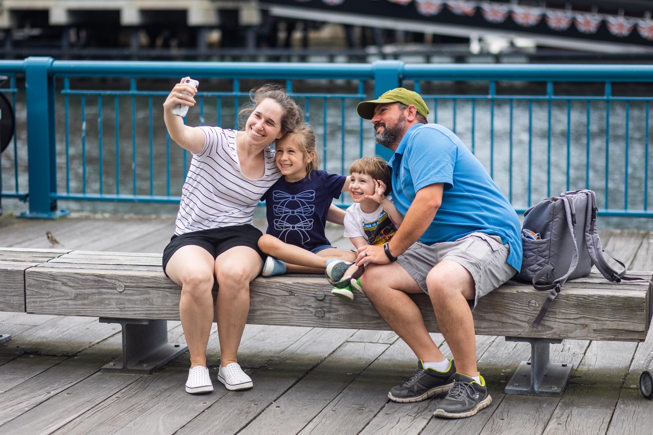 A family posing for a selfie on the waterfront
