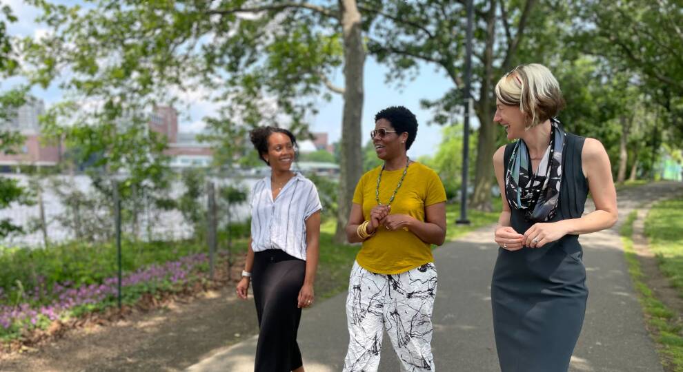 Alison Badrigian, director of projects and planning at Esplanade Association; Nicole Obi, president and CEO of the Black Economic Council of Massachusetts; and Jen Mergel, executive director of the Esplanade Association, walk down the Esplanade